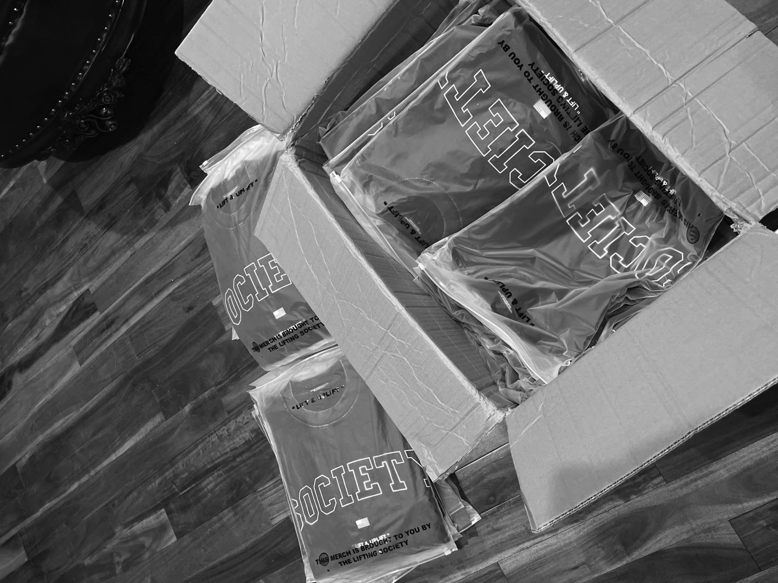 Boxes of folded Society tees staged for fulfillment.